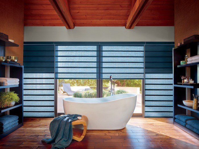 A bathroom with a free-standing bathtub and potted plants.